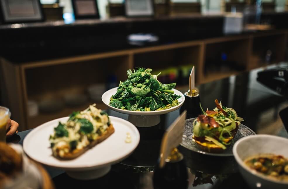 Plates of food nicely presented on a glass countertop.